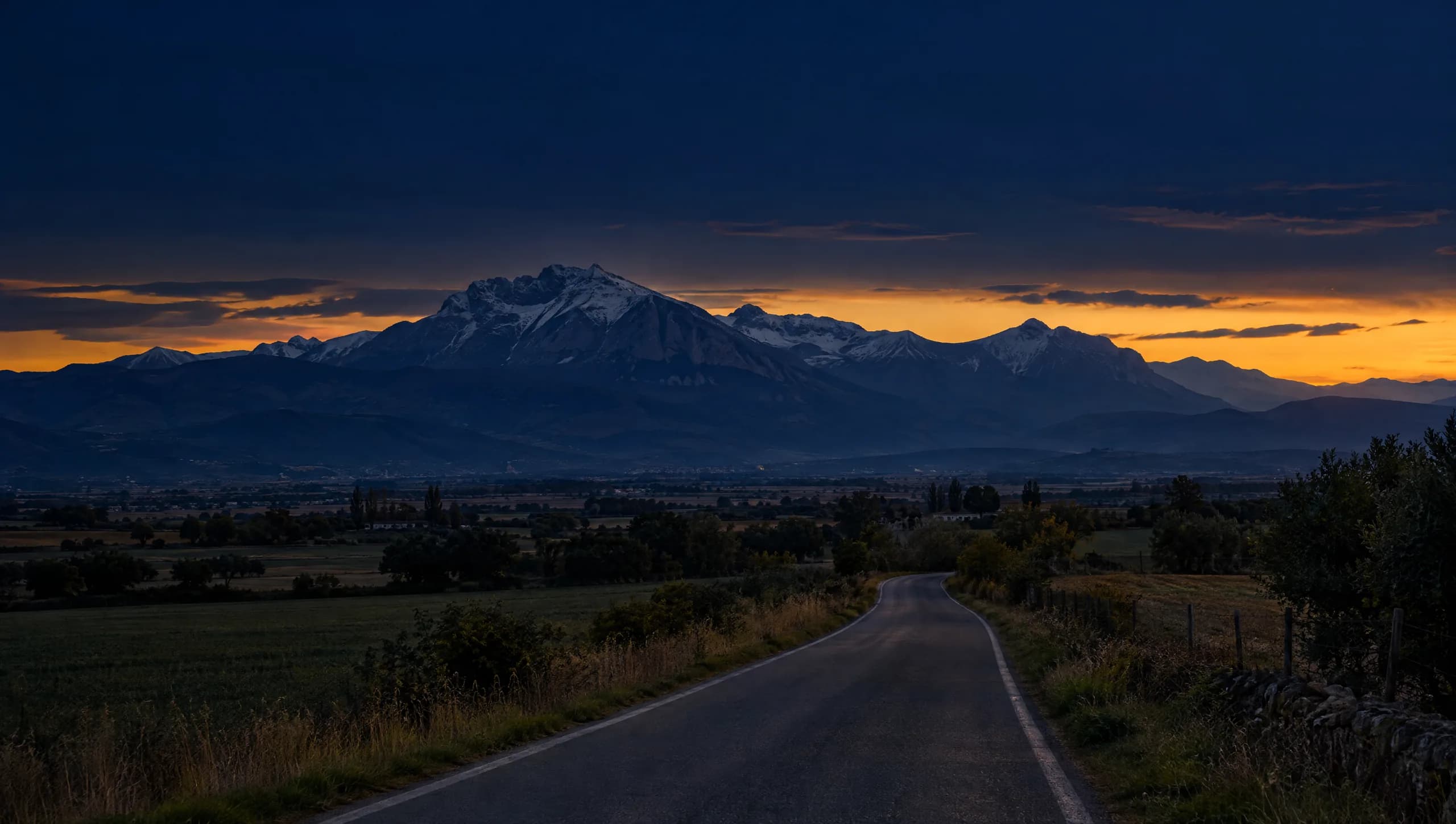 Strada di campagna verso le montagne al tramonto